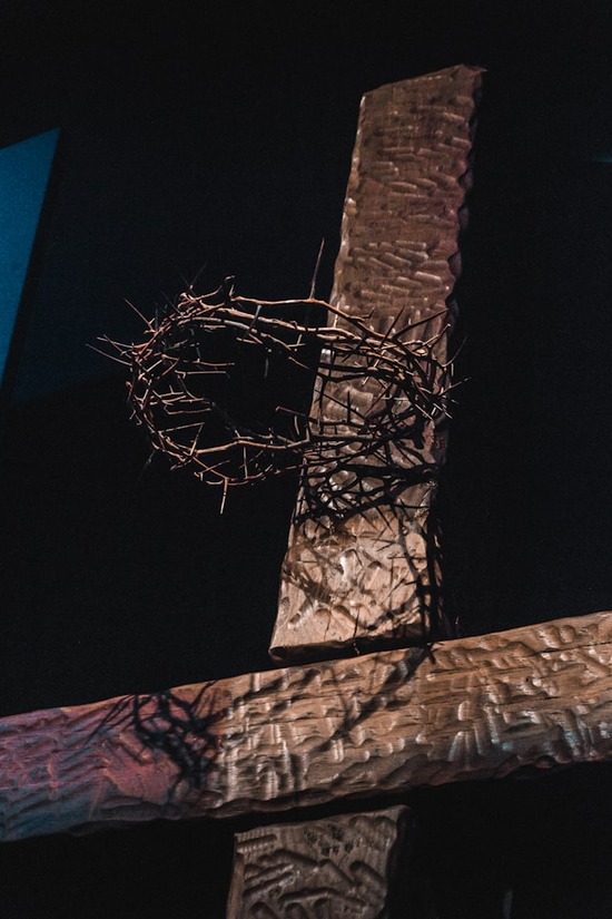 Crown of thorns on a cross A wooden cross stands as a crown of thorns hangs suspended at the top of the cross where Jesus' head would have been.