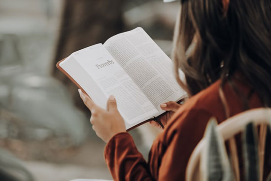 Woman reading the book of Proverbs as we learn about the wise saying of King Solomon, meant to guide God's people.