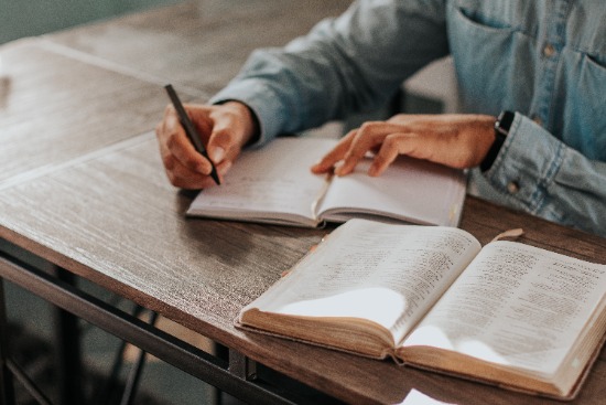 Man studying Bible Bible open to the parable of the prodigal son in the book of Luke
