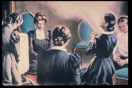 A drawing of Ellen White receiving a vision as she kneels in prayer with other women at a women's prayer meeting. 