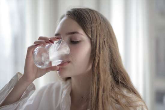 Woman drinking water Young woman drinking water from a glass.