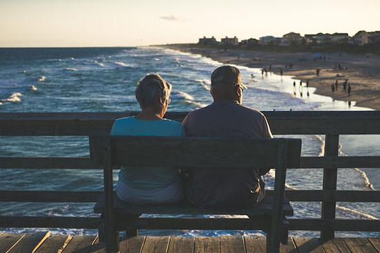 An older couple sit outside and enjoy the health benefits of fresh air and nature