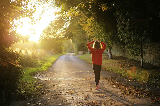 A lady on a walk in the morning to get exercise and sunlight