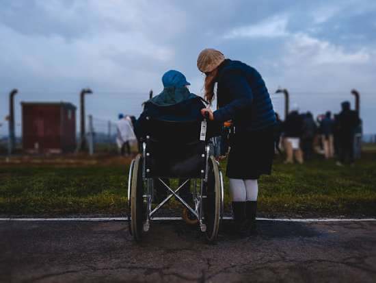 A woman focused on helping someone in a wheelchair in need