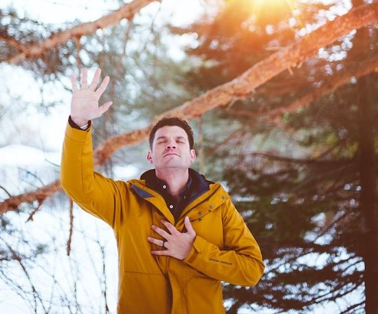 A man raising his hand to God in prayer and faith