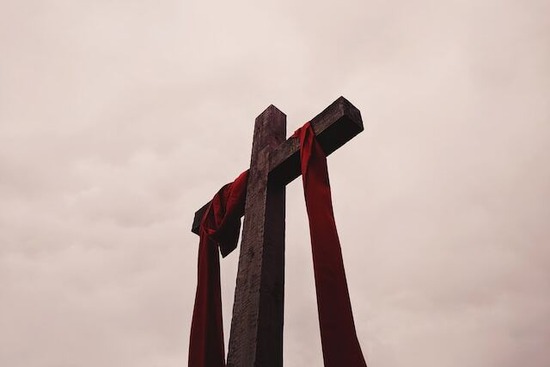 A cross with a red cloth draped over it to represent Jesus' death on Good Friday