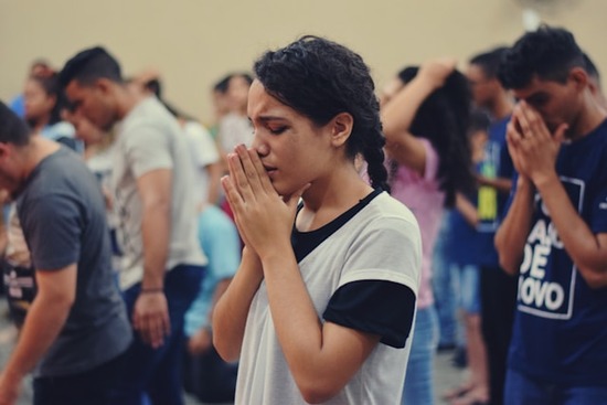A woman and other people in church praying