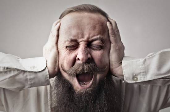 A man covers his ears while screaming, illustrating what may come to mind when hearing about demonic possession.
