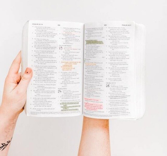  A hand holding an open Bible and claiming God's promises to resist temptation