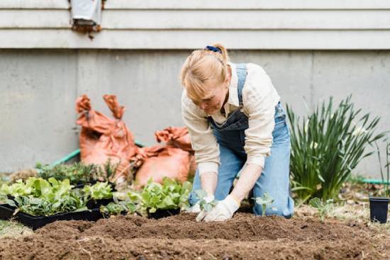A woman plants a garden, demonstrating the hard work that goes into country living.