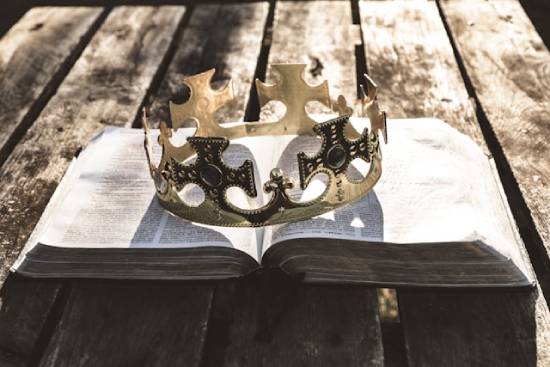 A king's crown resting on top of an open Bible