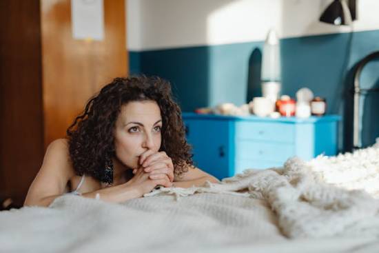 A woman praying by her bed for her children