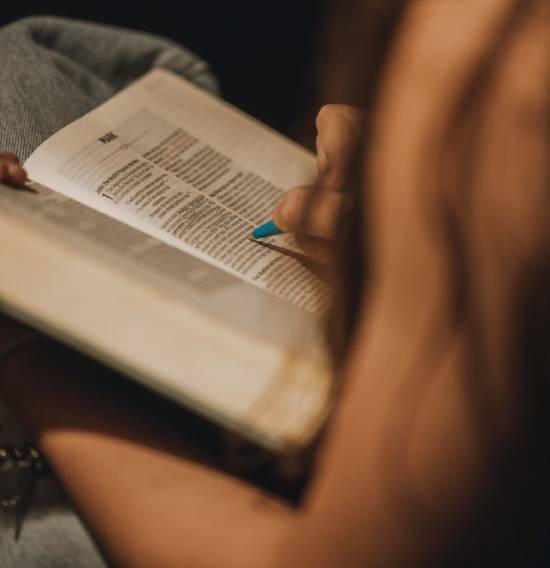 A woman highlights a verse in the first chapter of Mark.