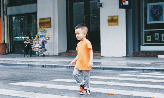 A child crosses a crosswalk by himself, and it demonstrates how God views us as a protective dad views His children and their choices
