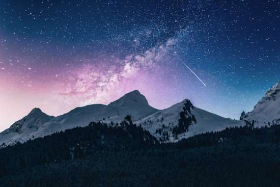 Tall mountains under a starry night sky, illustrating how outer space is sometimes called heaven.