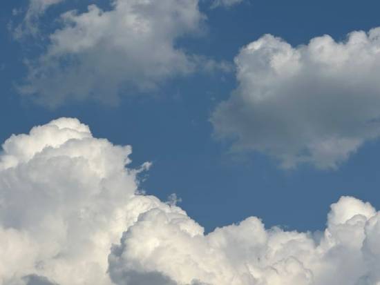A blue sky with white, puffy clouds.