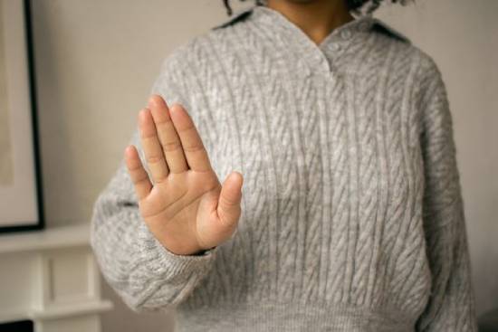 A woman doing stop gesture signifying she's rejecting something a woman holds out her hand to signal