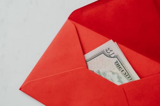 An orange envelope with money inside