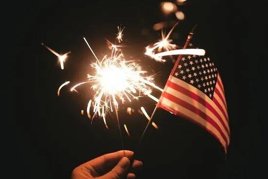 An American flag with fireworks in the background to represent the patriotic holidays Adventists celebrate